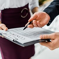 cropped view of businesspeople signing contract in office